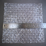 Sheet of bubble wrap with a ruler for scale on a dark background